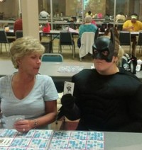 #33 Batman or another superhero playing bingo at a crowded recreation center.